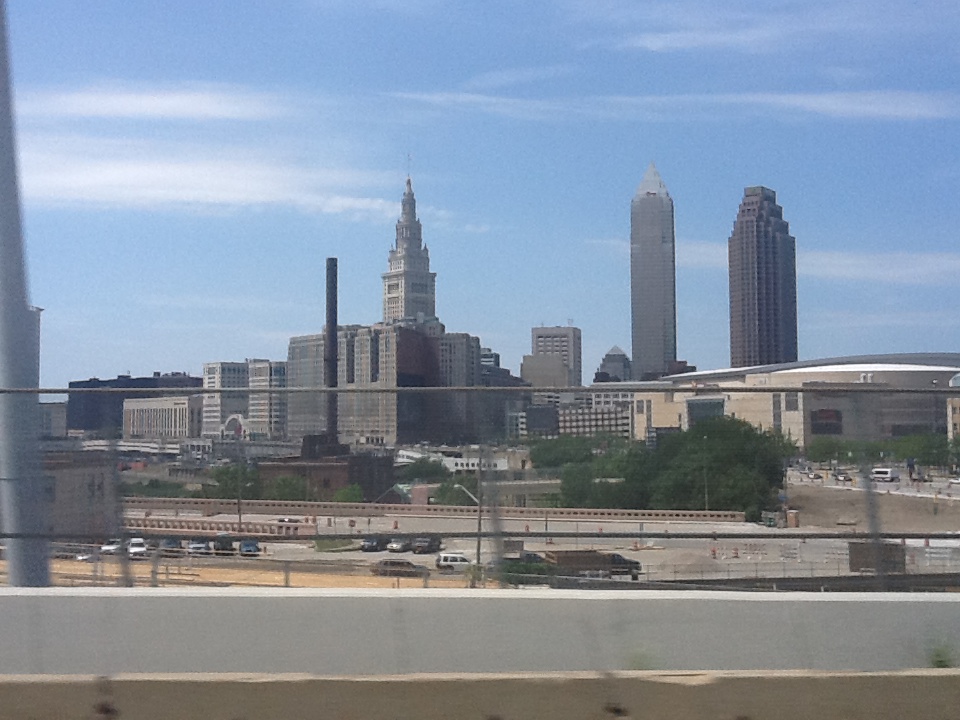 City skyline featuring modern buildings and a historic tower under a clear blue sky.